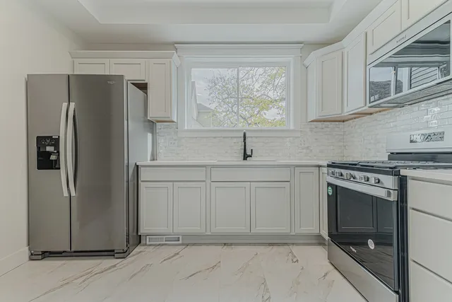 a kitchen with white cabinets and stainless steel appliances