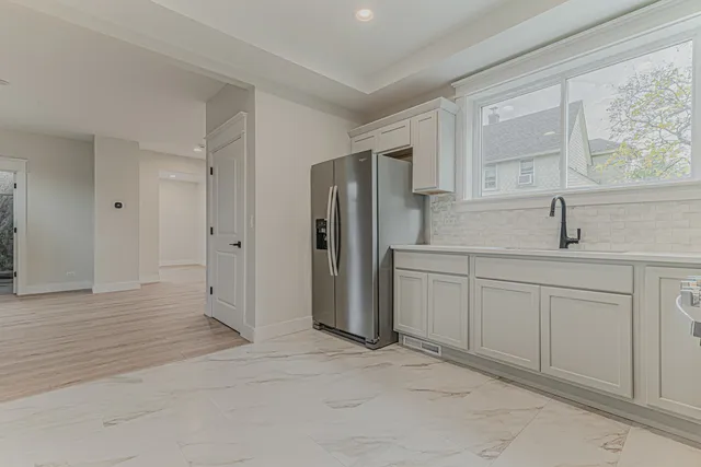 a kitchen with white cabinets and window