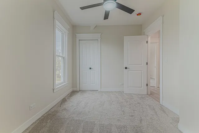 an empty room with cabinet and ceiling fan
