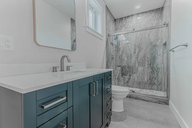 a bathroom with a sink a toilet and shower