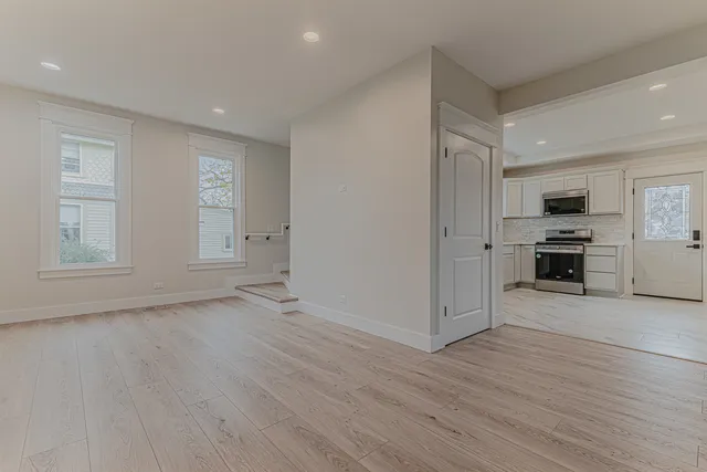 a view of a kitchen with wooden floor electronic appliances and window