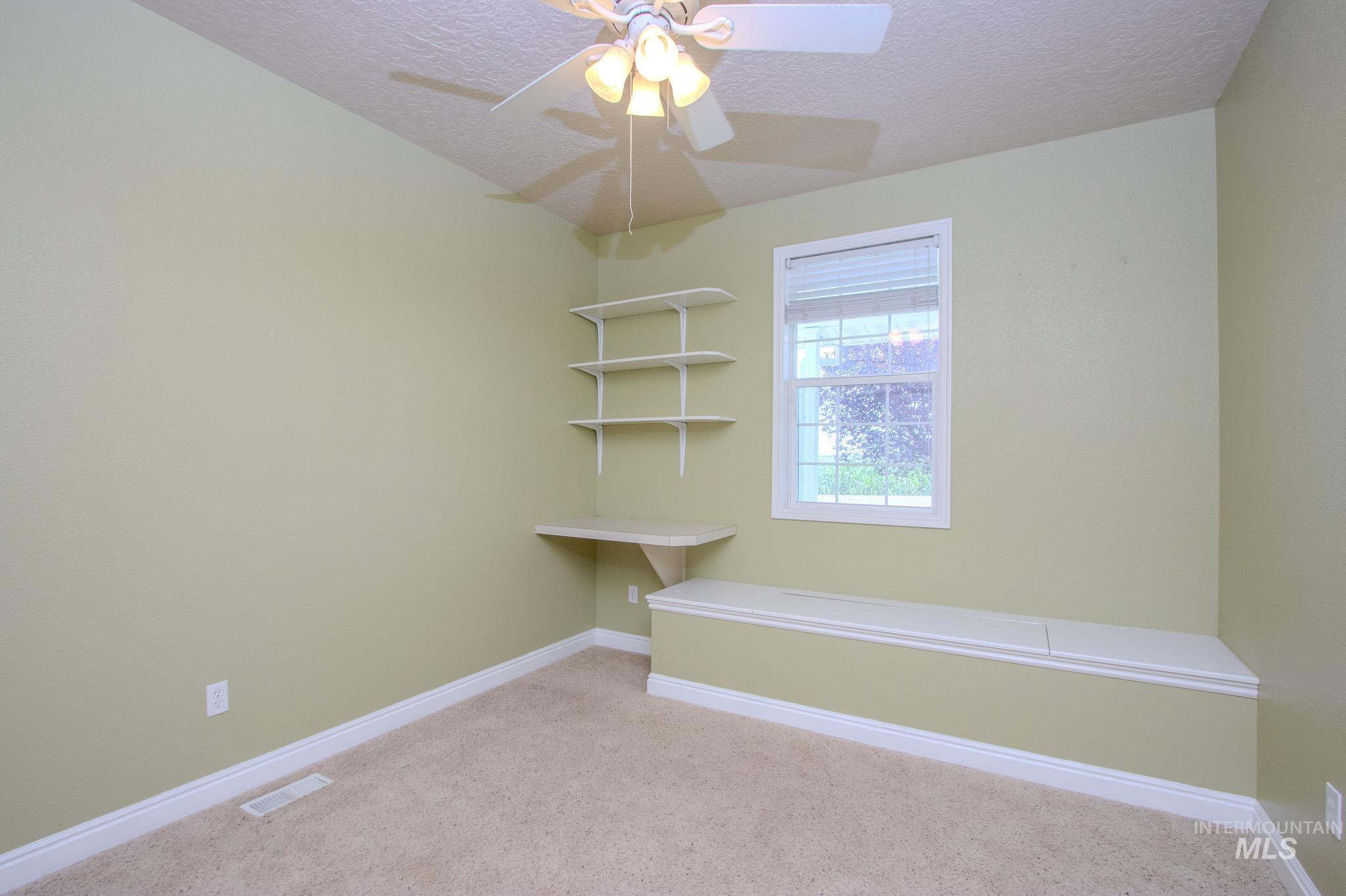 13569 Midway Road Nampa, ID 83651 - Photo 17 of 25 Empty room featuring a textured ceiling, light carpet, and ceiling fan