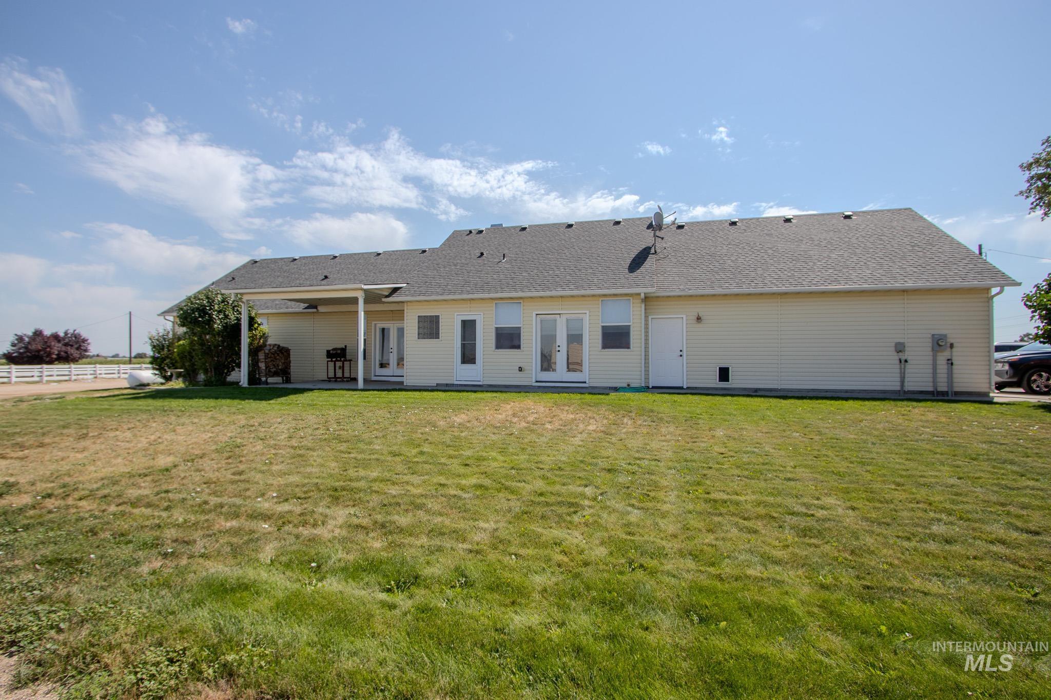 13569 Midway Road Nampa, ID 83651 - Photo 5 of 25 Back of property featuring french doors, a shingled roof, a yard, and a patio area