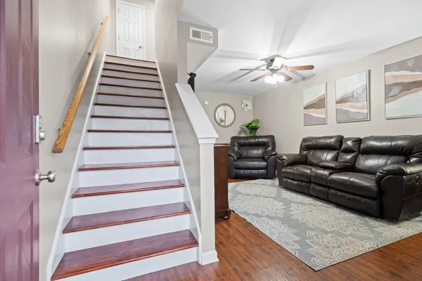 a living room with furniture and a ceiling fan