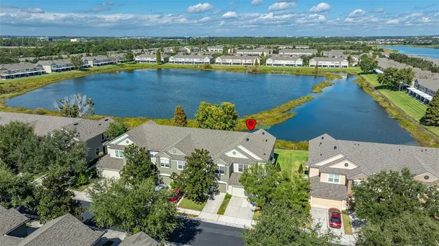 an aerial view of residential houses with outdoor space and lake view