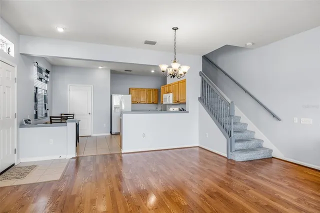 a view of a living room and a kitchen with wooden floor