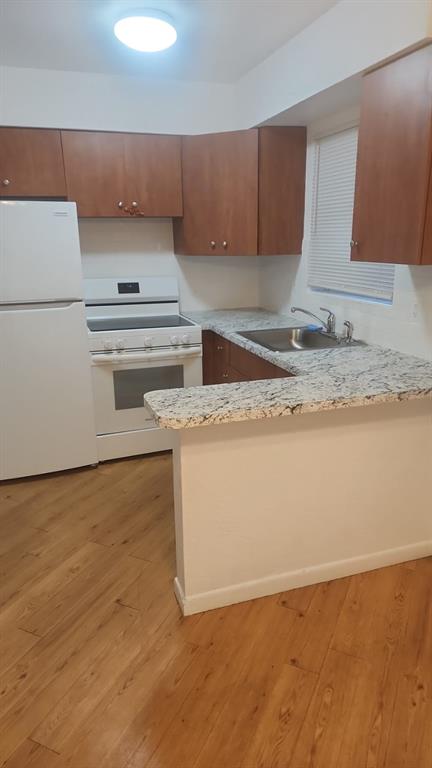 a kitchen with granite countertop a stove a sink and a microwave
