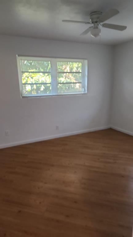 5250 Southwest 90th Way, Unit 3 Cooper City, FL 33328 - Photo 3 of 8 a view of an empty room with wooden floor and a window
