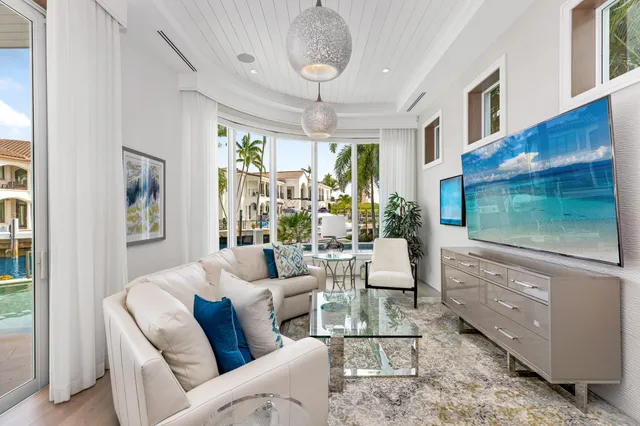 a living room with furniture a floor to ceiling window and a flat screen tv
