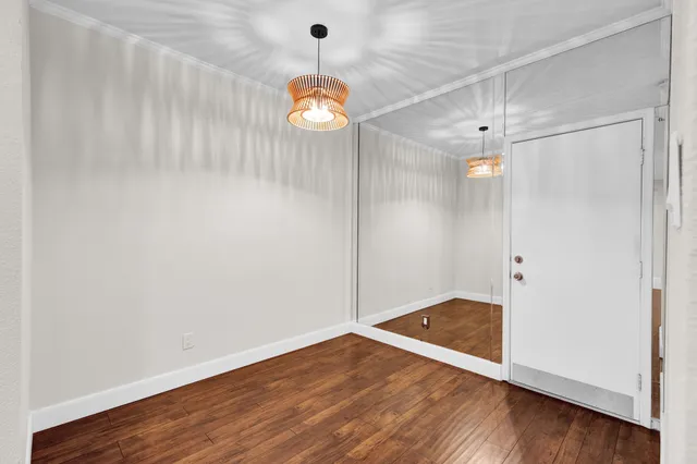 an empty room with wooden floor and window