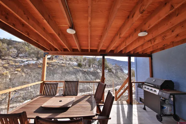 a backyard of a house with barbeque oven table and chairs