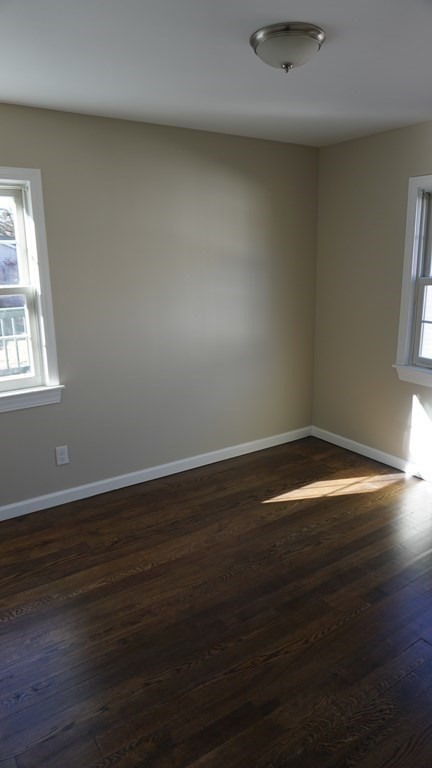 70 Canterbury Road Springfield, MA 01118 - Photo 11 of 36 an empty room with wooden floor and windows