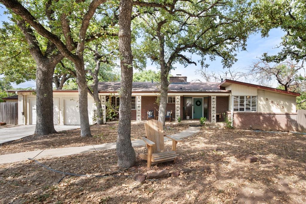a view of a house with a tree in the yard