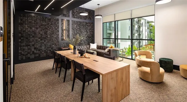 a dining hall with couches a flat tv screen and a dining table with garden view