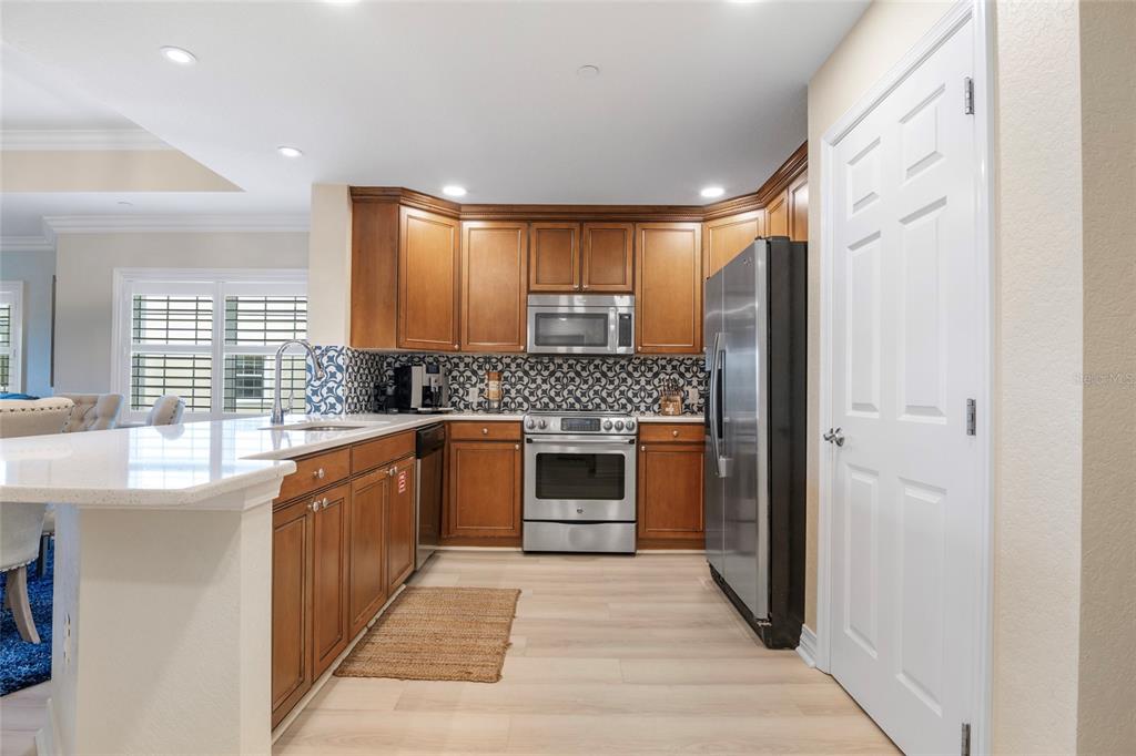 7600 Sandy Ridge Drive, Unit 204 Reunion, FL 34747 - Photo 16 of 39 a large kitchen with stainless steel appliances granite countertop a stove a sink and a refrigerator