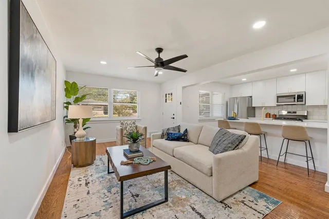 a living room with furniture kitchen view and a window