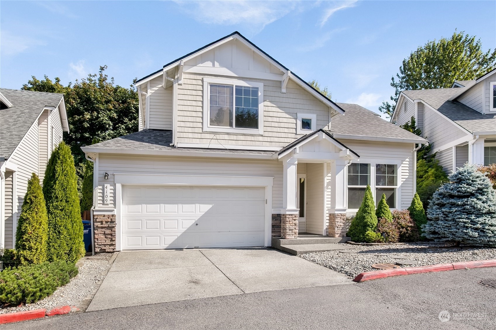 4109 South 220th Place, Unit 18 Kent, WA 98032 - Photo 2 of 29 a view of a white house with a yard and potted plants