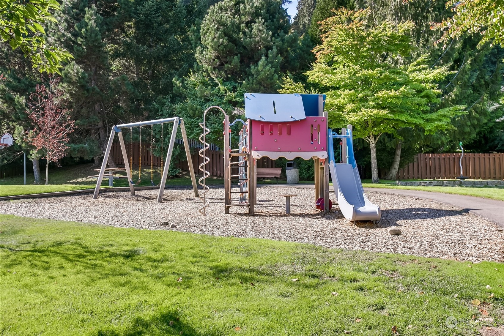 4109 South 220th Place, Unit 18 Kent, WA 98032 - Photo 28 of 29 a view of a backyard with a slide trees and wooden fence