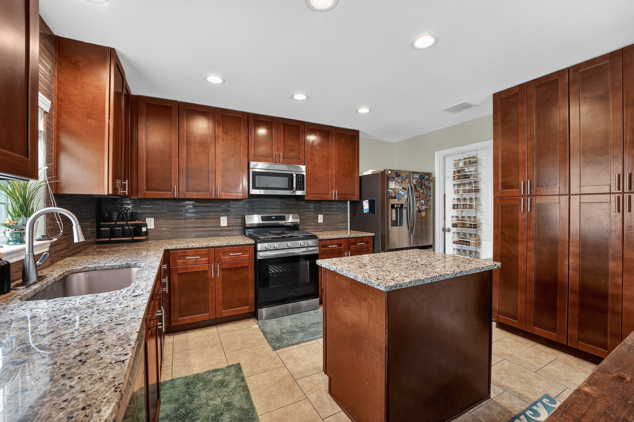 816 Rusk Road Round Rock, TX 78665 - Photo 17 of 29 Kitchen featuring extensive wood cabinetry, light-toned granite countertops, and stainless steel appliances