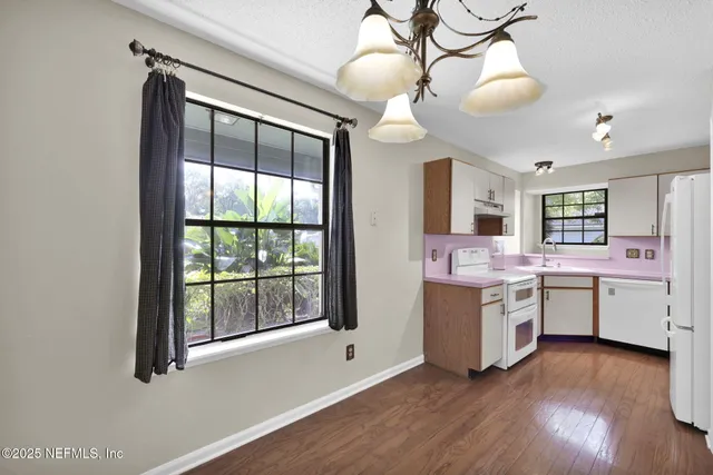 a kitchen with a sink and wooden floor