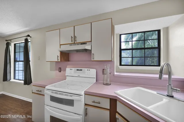 a kitchen with a sink stove and cabinets