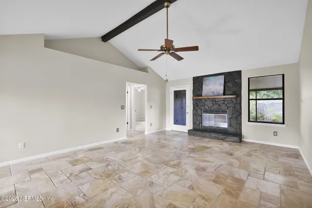 a view of empty room with a fireplace and fan