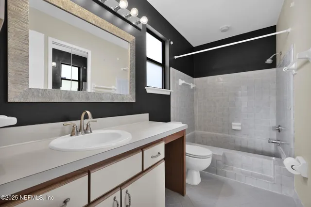 a bathroom with a sink a toilet a mirror and shower