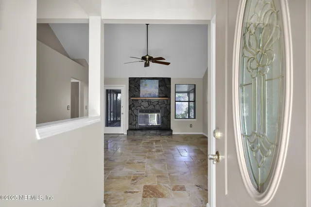 a view of a hallway with a fireplace and a window