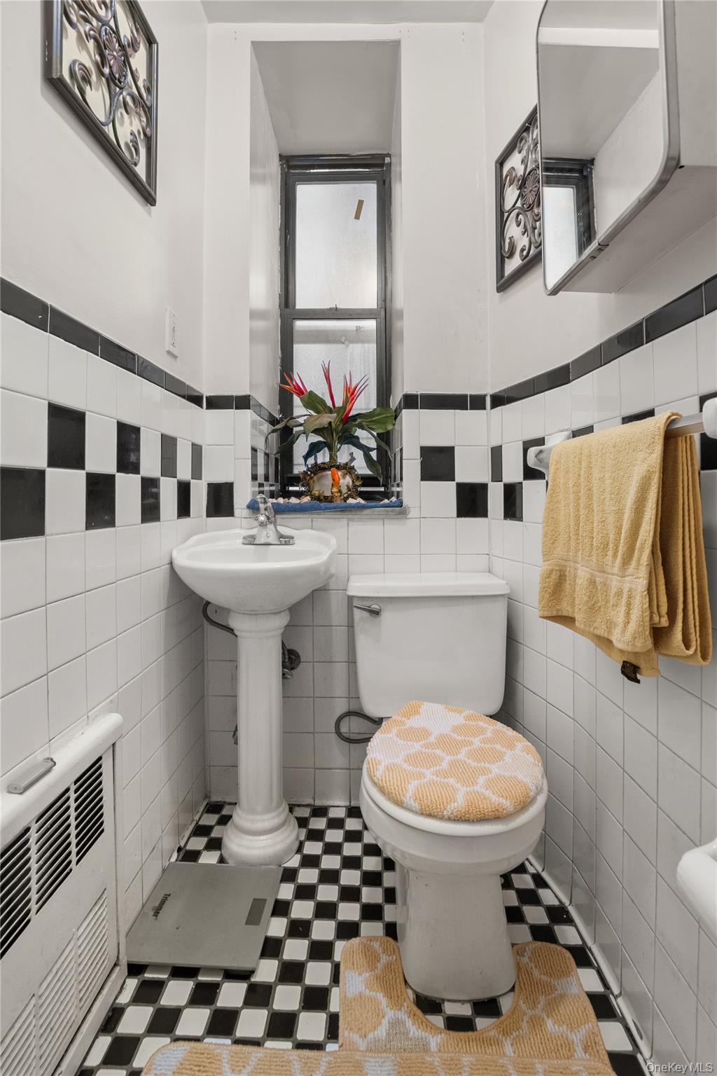 211 West 144th Street, Unit 2C Manhattan, NY 10030 - Photo 12 of 14 Half bath featuring tile walls, heating unit, and wainscoting