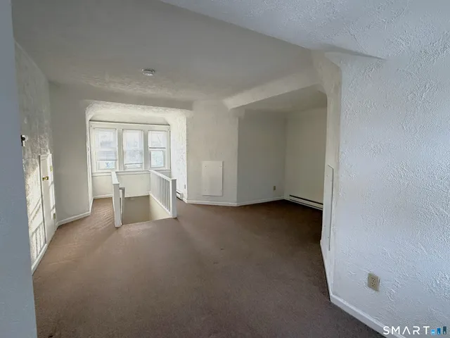 a view of a livingroom with an empty space and a window