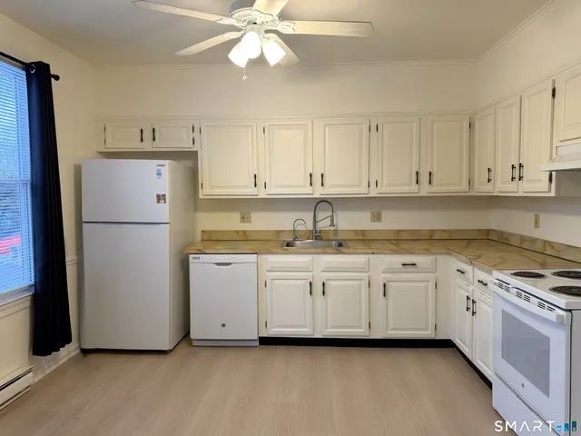 a kitchen with granite countertop white cabinets and white appliances