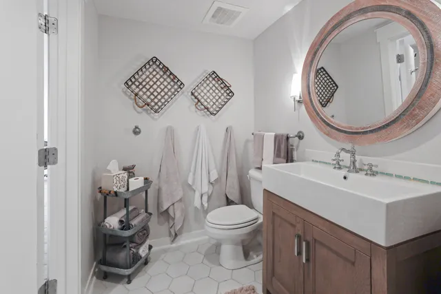a bathroom with a toilet a sink and a mirror