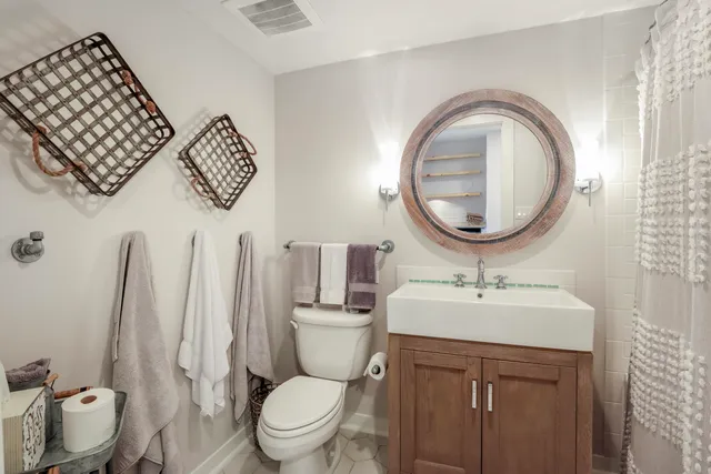 a bathroom with a toilet a sink and a mirror