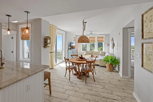 a view of a dining room and livingroom with furniture wooden floor a chandelier