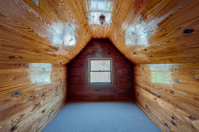 an empty room with a fan & a window