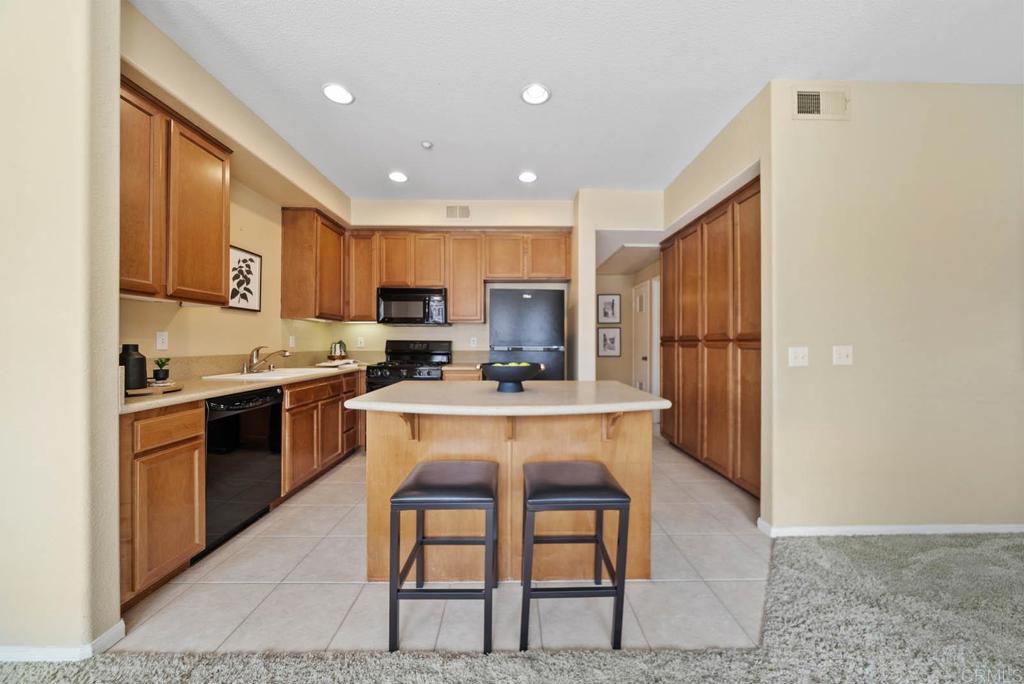 3223 Dehesa Road, Unit 32 El Cajon, CA 92019 - Photo 11 of 46 a kitchen with kitchen island granite countertop wooden cabinets and a refrigerator