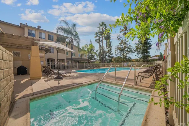 a view of swimming pool with outdoor seating and house in the background