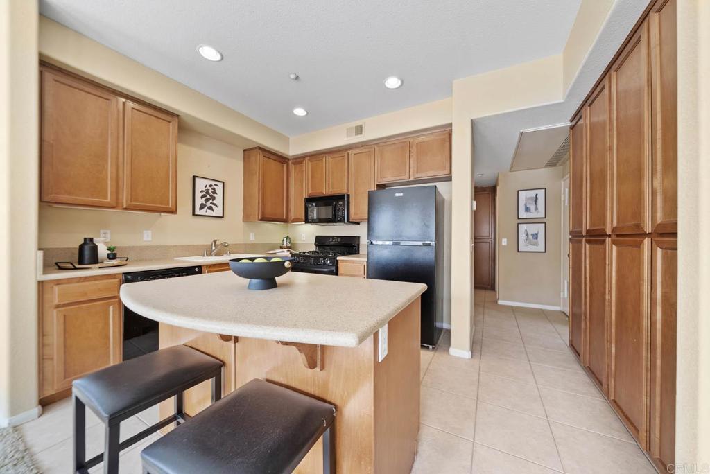 3223 Dehesa Road, Unit 32 El Cajon, CA 92019 - Photo 10 of 46 a kitchen with stainless steel appliances granite countertop a table chairs sink refrigerator and cabinets