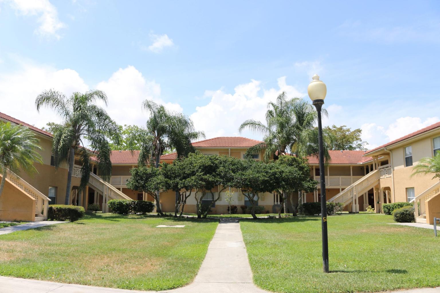 4799 Via Palm Lakes, Unit 1606 West Palm Beach, FL 33417 - Photo 1 of 29 a front view of a house with a yard and palm trees