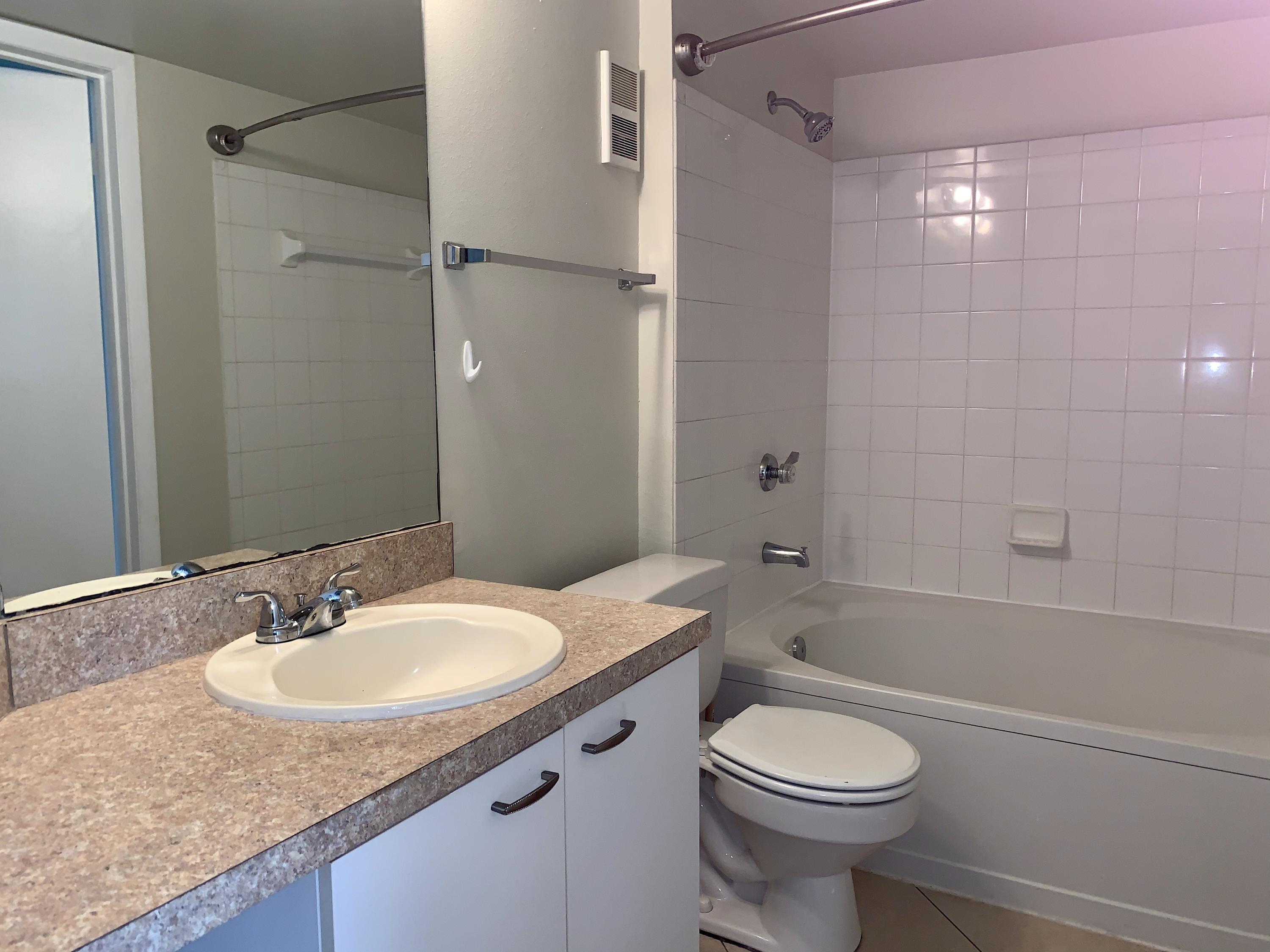 4799 Via Palm Lakes, Unit 1606 West Palm Beach, FL 33417 - Photo 14 of 29 a bathroom with a granite countertop sink toilet and shower