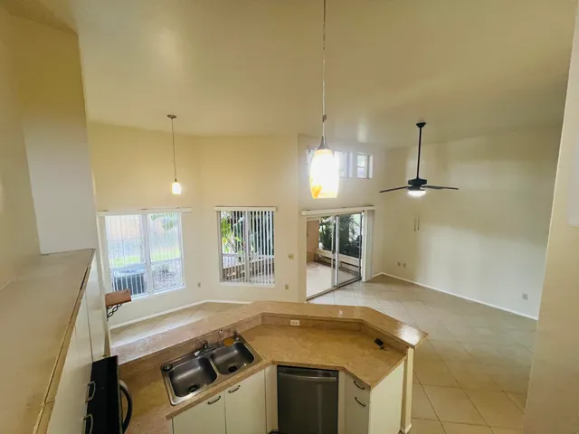 a view of a kitchen with a sink and dishwasher a stove top oven with wooden floor