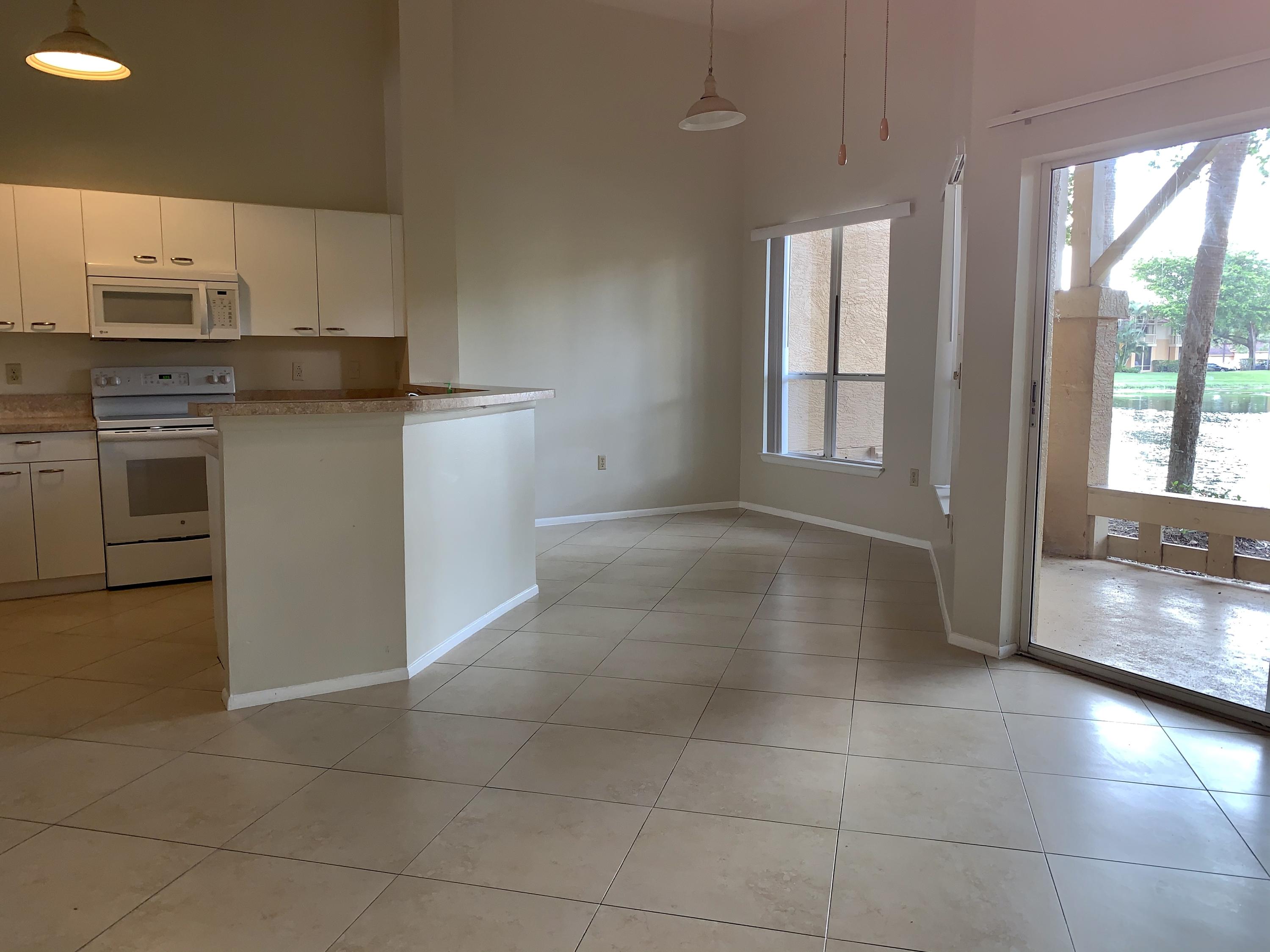4799 Via Palm Lakes, Unit 1606 West Palm Beach, FL 33417 - Photo 6 of 29 a kitchen with a stove a sink and a refrigerator