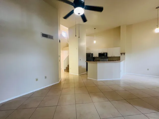 a kitchen with granite countertop a rug a stove a refrigerator and a counter top space