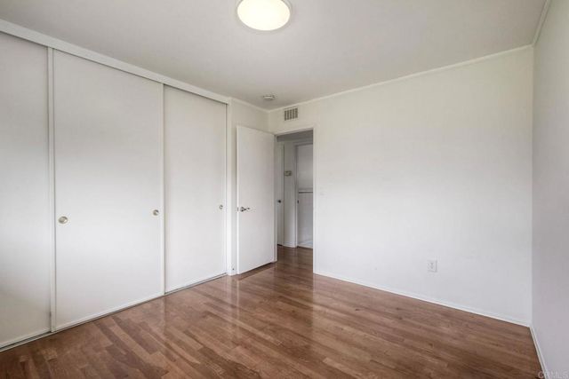 a bedroom with a bed and a lamp on dresser