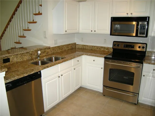 a kitchen with granite countertop a stove and a sink