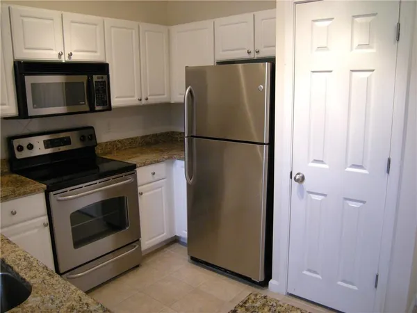 a white refrigerator freezer and a stove sitting inside of a kitchen