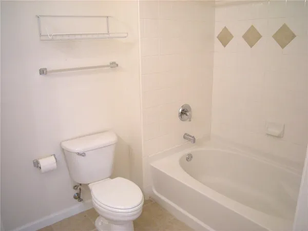 a white toilet sitting next to a bath tub
