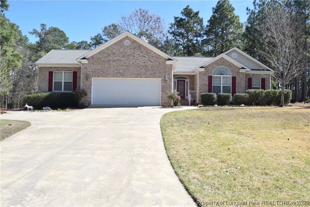 249 Rothbury Drive Whispering Pines, NC 28327 - Photo 1 of 26 a front view of a house with a yard covered with snow