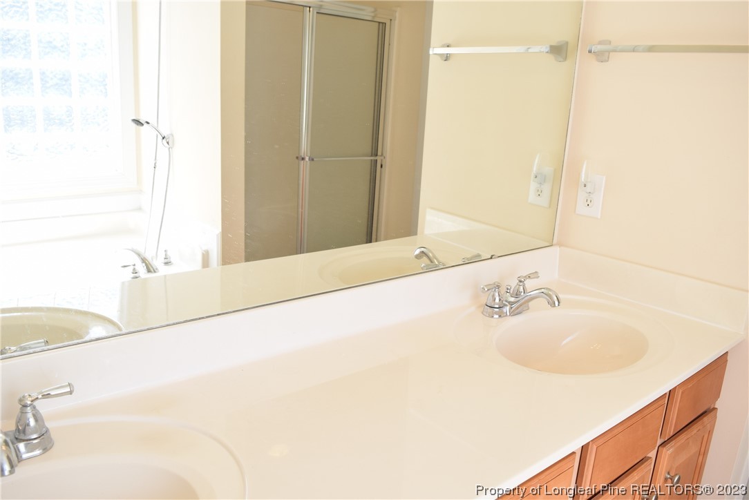 249 Rothbury Drive Whispering Pines, NC 28327 - Photo 17 of 26 a bathroom with a tub sink and mirror