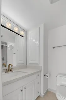 a kitchen with white cabinets and sink